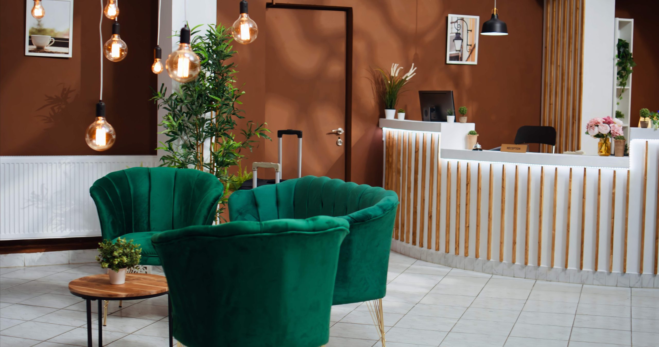 Le lobby d’un hôtel avec des sièges en velours verts et confortables